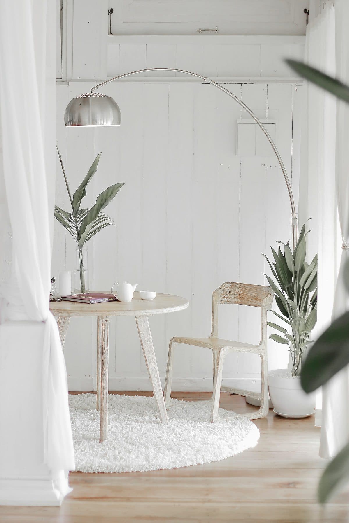 Rincón sereno y luminoso con una silla, una mesa y plantas